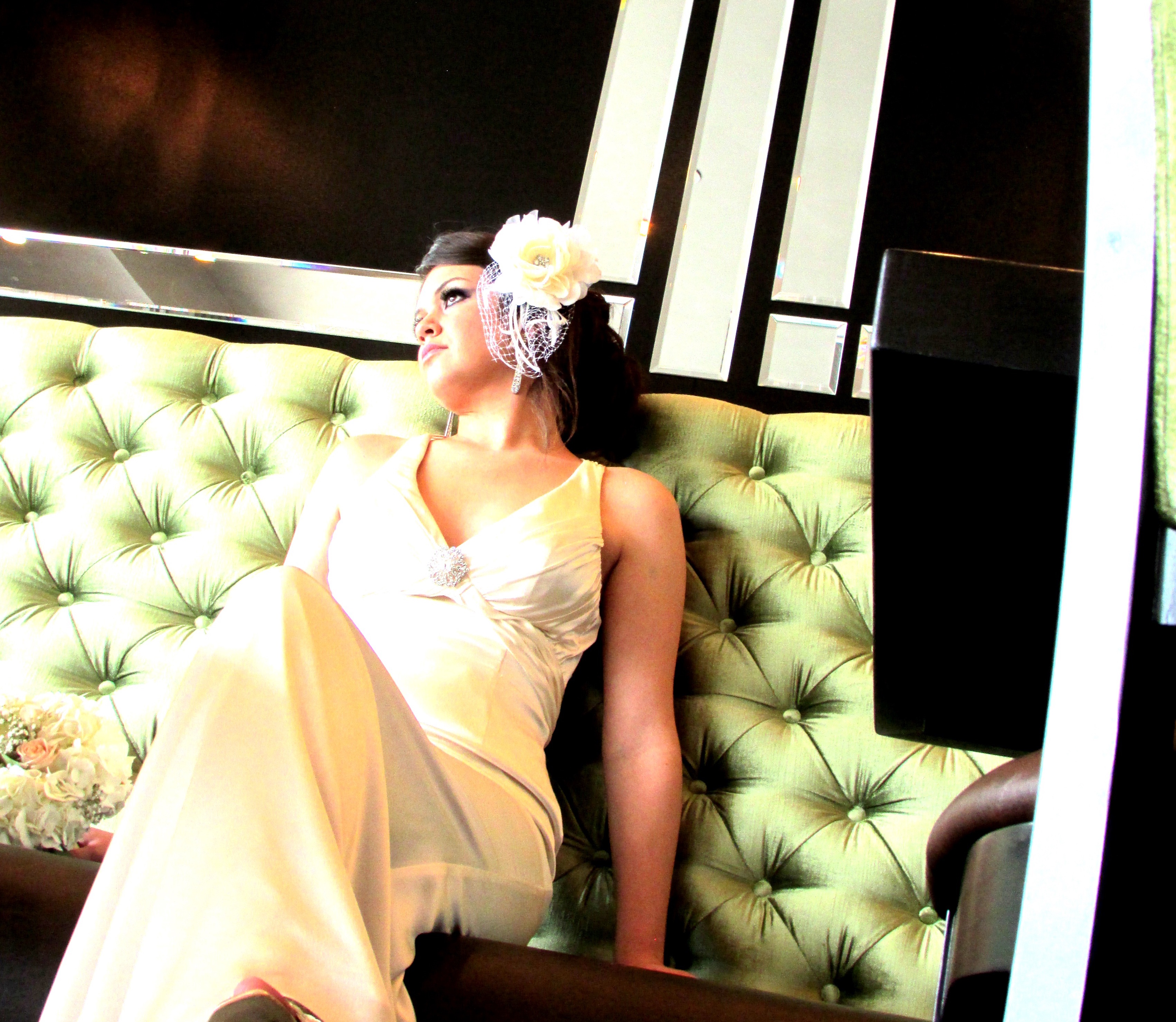 A bride in a white wedding dress seated in a booth at Flavor on Main.